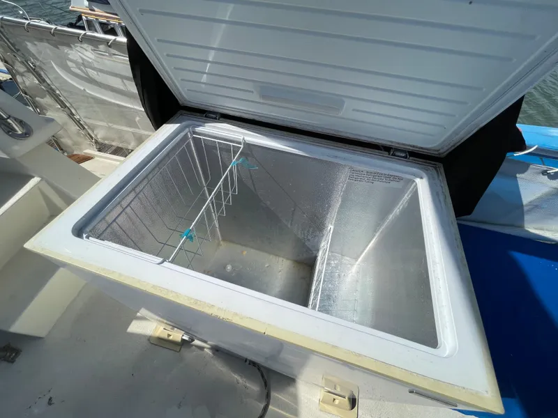 Slide: The Image of Open freezer on 1976 Hatteras 48 LRC boat deck, showing interior storage space. - 11