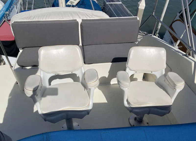 Slide: The Image of Two white captain's chairs on a 1976 Hatteras 48 LRC yacht deck. - 13