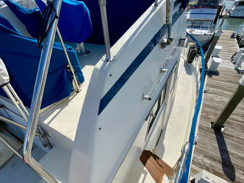 Slide: The Image of 1976 Hatteras 48 LRC yacht docked, featuring sleek design and blue accents. - 14