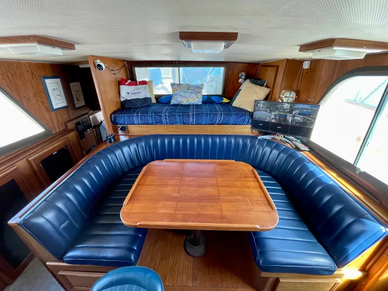 Slide: The Image of 1976 Hatteras 48 LRC interior with blue leather seating and wooden table. - 20