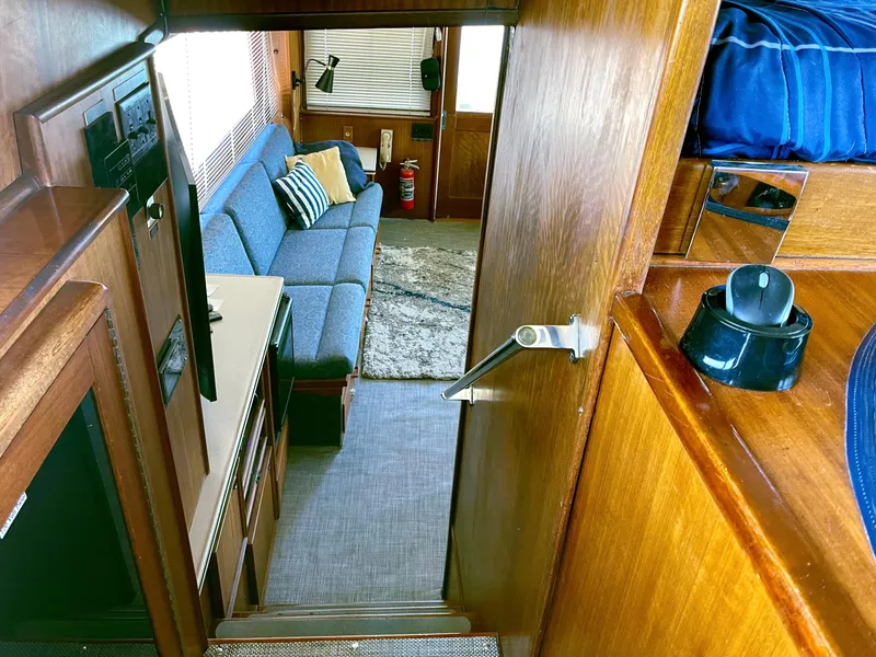 Slide: The Image of Interior of 1976 Hatteras 48 LRC yacht, featuring cozy seating and wooden finishes. - 21