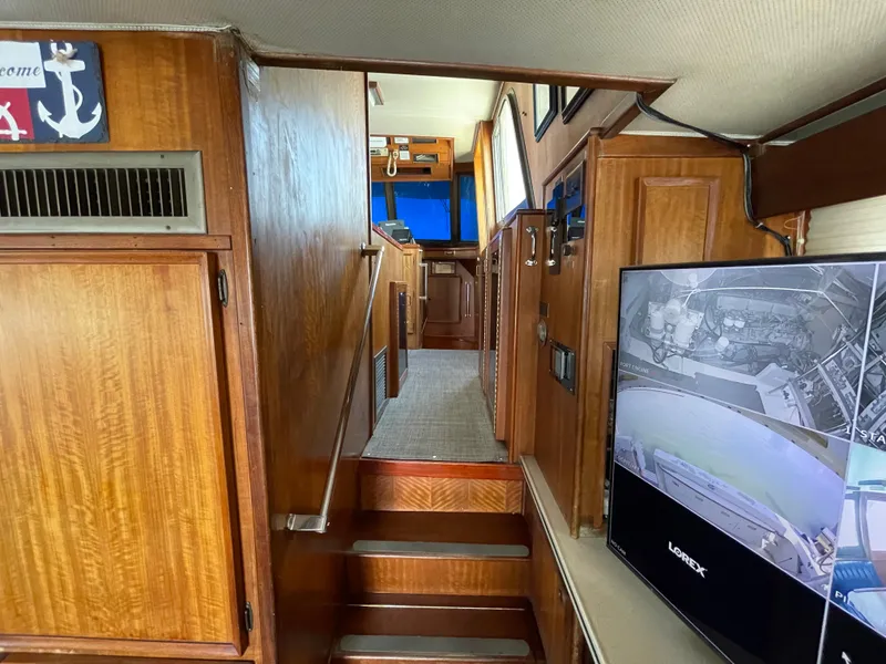 Slide: The Image of Interior of 1976 Hatteras 48 LRC yacht with wooden paneling and modern electronics. - 25