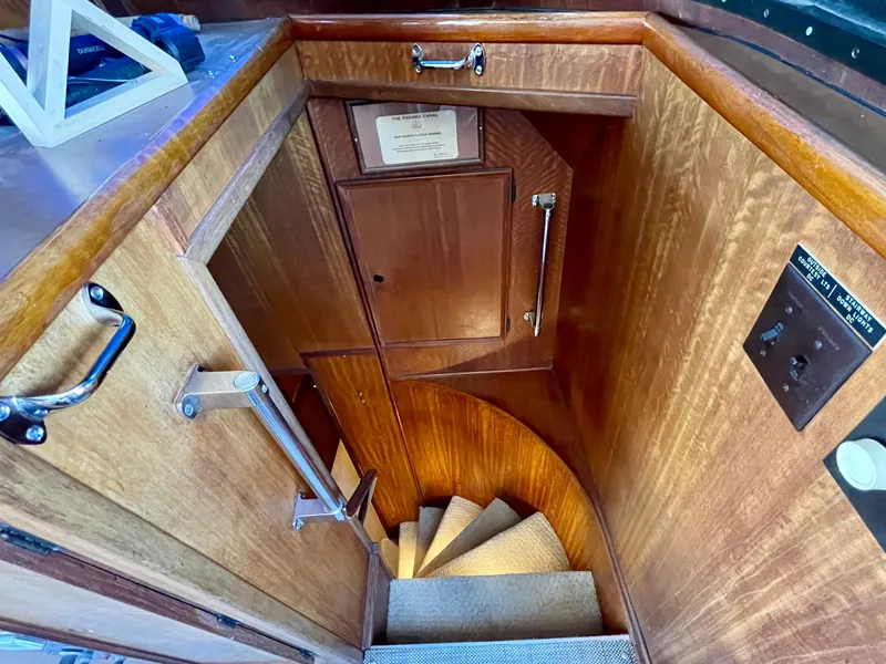 Slide: The Image of 1976 Hatteras 48 LRC interior staircase with wooden paneling and carpeted steps. - 27