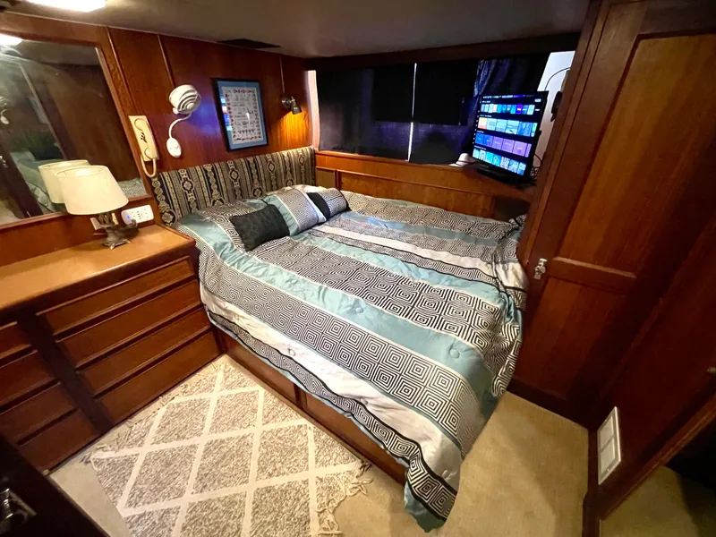 Slide: The Image of Cozy bedroom in 1976 Hatteras 48 LRC yacht with wood paneling and patterned bedding. - 29