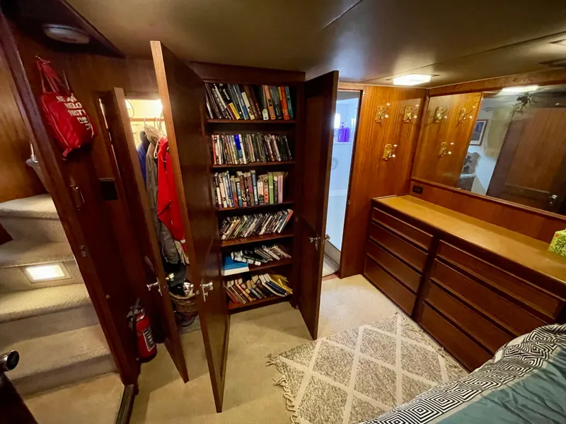 Slide: The Image of 1976 Hatteras 48 LRC interior with bookshelf, dresser, and cozy bedroom setting. - 31