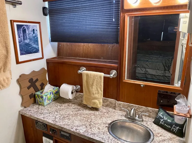 Slide: The Image of 1976 Hatteras 48 LRC bathroom with granite countertop, sink, and wooden cabinetry. - 32