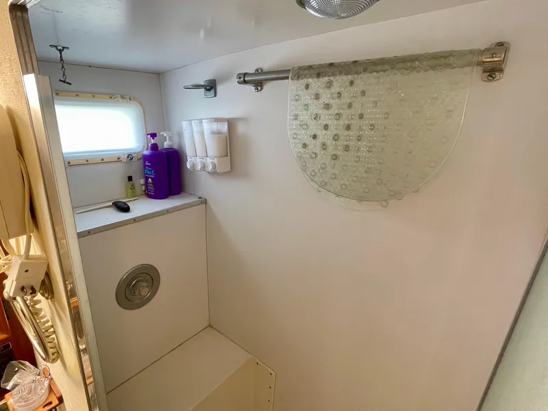 Slide: The Image of Bathroom interior of a 1976 Hatteras 48 LRC yacht, featuring a shower and toiletries. - 33