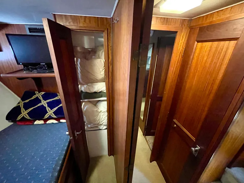 Slide: The Image of Interior of 1976 Hatteras 48 LRC yacht with wood paneling, bunk beds, and TV. - 34