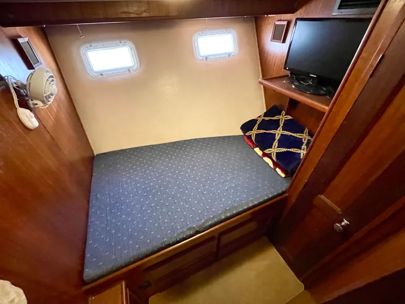 Slide: The Image of 1976 Hatteras 48 LRC cabin with bed, portholes, and TV. Cozy marine interior. - 35