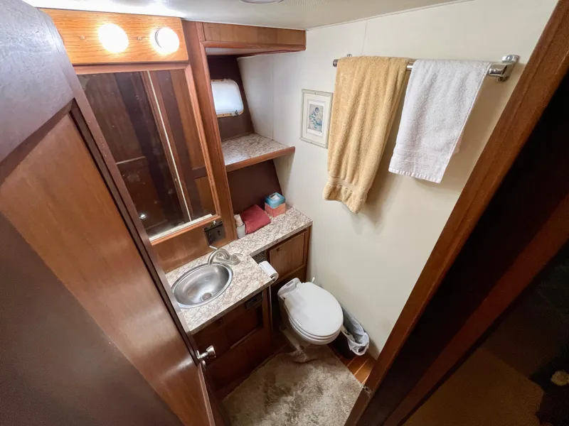 Slide: The Image of 1976 Hatteras 48 LRC yacht bathroom with sink, toilet, and towels. - 36
