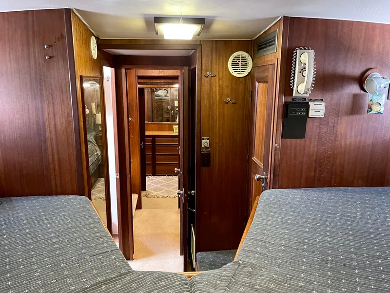 Slide: The Image of 1976 Hatteras 48 LRC interior with wood paneling and twin beds. - 40
