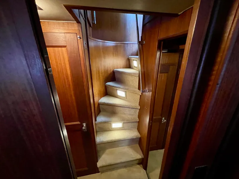 Slide: The Image of Interior staircase of 1976 Hatteras 48 LRC yacht with wooden paneling and carpeted steps. - 41