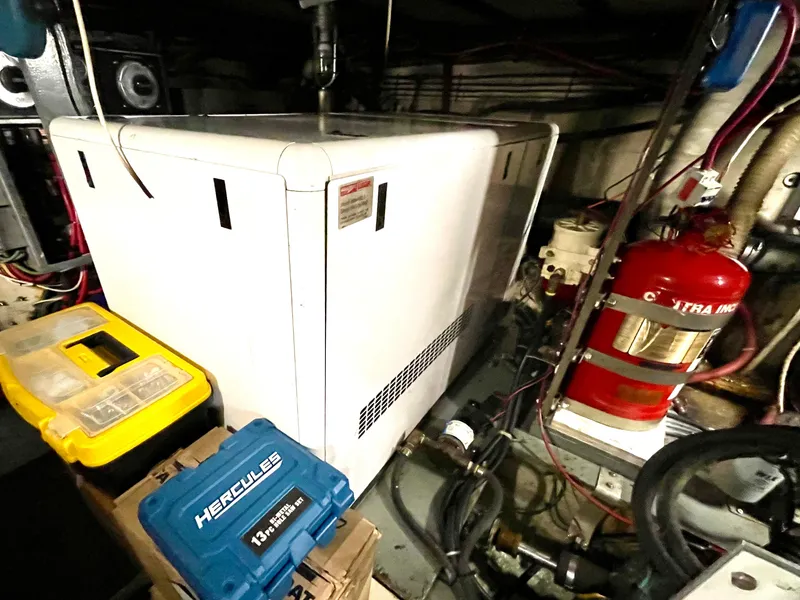 Slide: The Image of Engine room of 1976 Hatteras 48 LRC with equipment and storage boxes. - 49