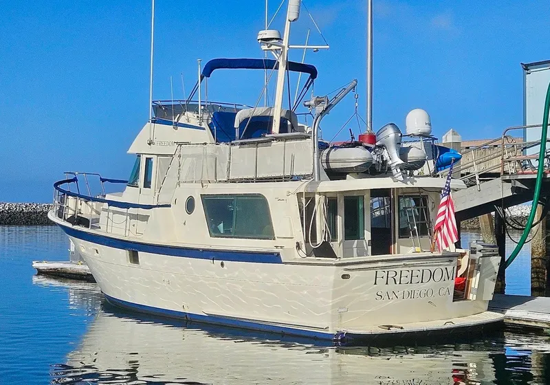 Slide: The Image of 1976 Hatteras 48 LRC yacht docked in San Diego harbor, displaying American flag. - 6
