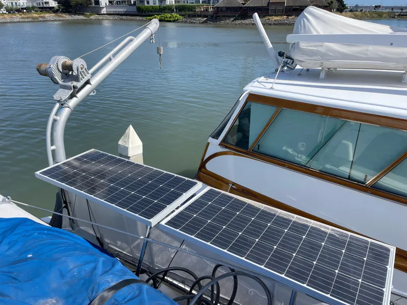 Slide: The Image of 1976 Hatteras 48 LRC with solar panels docked by the water. - 8