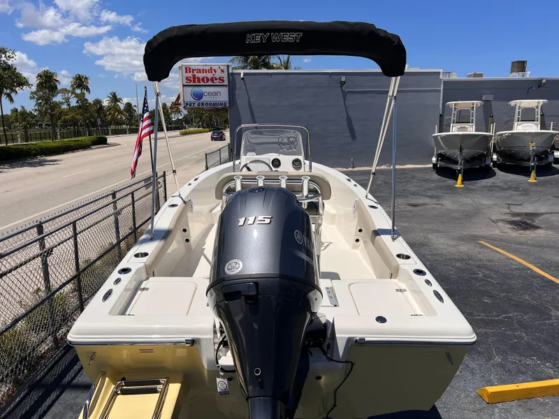 Slide: The Image of 2025 Key West 179 FS boat with 115 HP engine, parked outdoors under clear blue sky. - 9