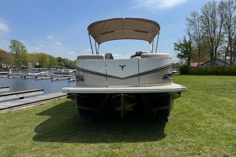 Slide: The Image of 2025 Tahoe Pontoon LTZ Quad Lounger Shift on grassy lakeside, sunny day. - 1