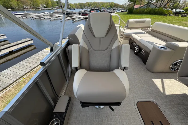 Slide: The Image of 2025 Tahoe Pontoon LTZ Quad Lounger Shift interior with plush seating by a lakeside dock. - 11