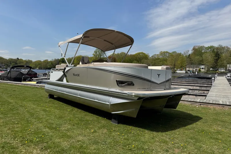 Slide: The Image of 2025 Tahoe Pontoon LTZ Quad Lounger Shift on grass near dock, under blue sky. - 19