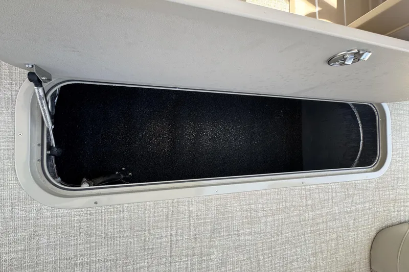 Slide: The Image of 2025 Tahoe Pontoon LTZ Quad Lounger Shift storage compartment, open and empty. - 3