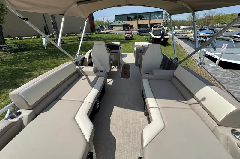 Slide: The Image of 2025 Tahoe Pontoon LTZ Quad Lounger Shift with spacious seating and canopy at a marina. - 5