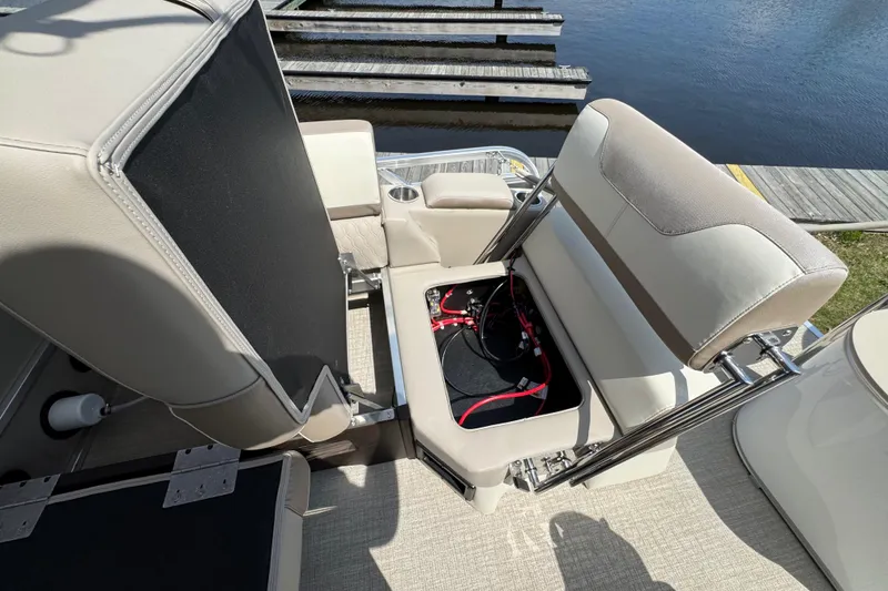 Slide: The Image of 2025 Tahoe Pontoon LTZ Quad Lounger Shift with open storage compartment by the dock. - 7
