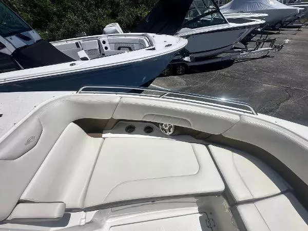 Slide: The Image of 2014 Chaparral 307 SSX boat interior with white seating, docked alongside other boats. - 13