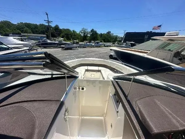 Slide: The Image of 2014 Chaparral 307 SSX boat interior with seating, docked in a marina under clear blue sky. - 15