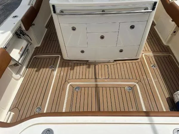 Slide: The Image of 2018 Scout 350 LXF boat deck with teak flooring and storage compartments. - 10