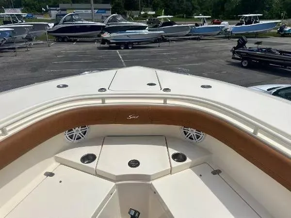 Slide: The Image of 2018 Scout 350 LXF boat interior with brown seating, parked among other boats. - 24