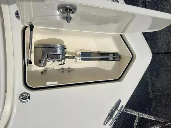 Slide: The Image of Anchor compartment of 2018 Scout 350 LXF boat, open with visible anchor and mechanism. - 25