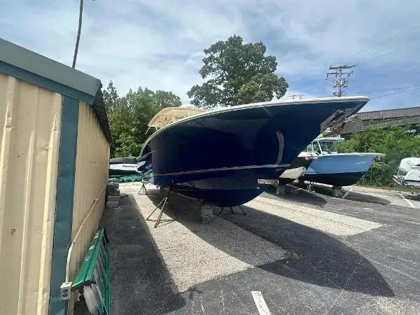 Slide: The Image of 2018 Scout 350 LXF boat on dry dock, blue hull, outdoor storage. - 3