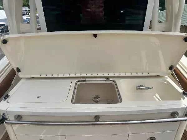 Slide: The Image of 2018 Scout 350 LXF boat with open storage compartment and sink. - 7