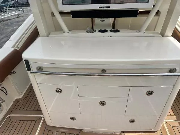Slide: The Image of 2018 Scout 350 LXF boat interior with storage compartments and teak flooring. - 8