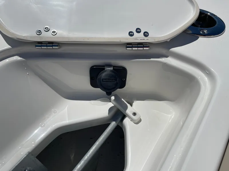 Slide: The Image of 2025 Key West 219 FS boat storage compartment with open lid and visible hardware. - 17