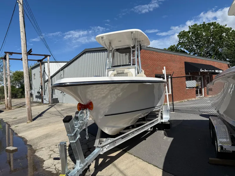 Slide: The Image of 2025 Key West 219 FS boat on trailer, parked outdoors near industrial buildings. - 4