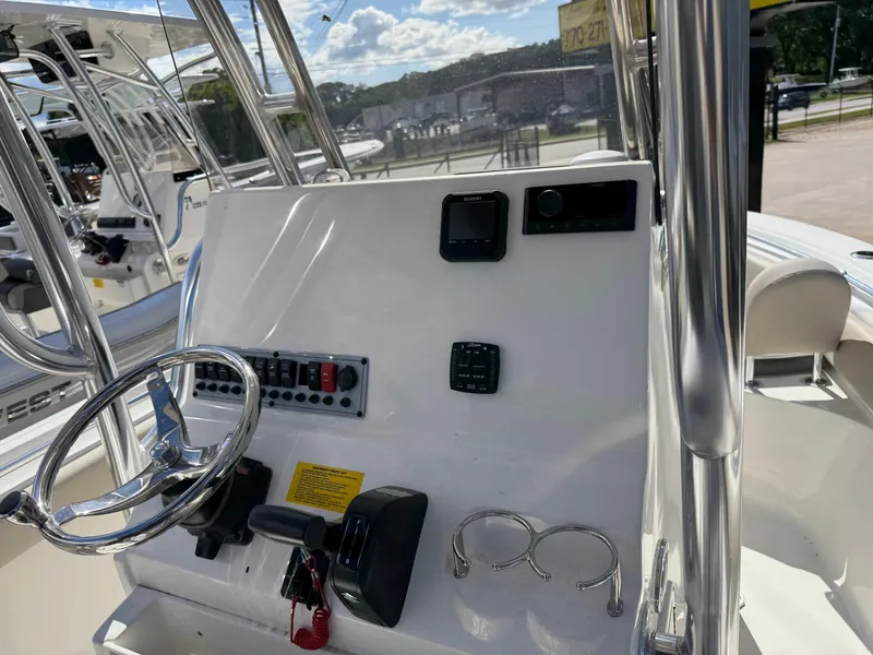 Slide: The Image of 2025 Key West 219 FS boat console with steering wheel, controls, and cup holders. - 6
