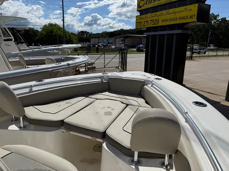 Slide: The Image of 2025 Key West 219 FS boat with cushioned seating, displayed outdoors under a sunny sky. - 8