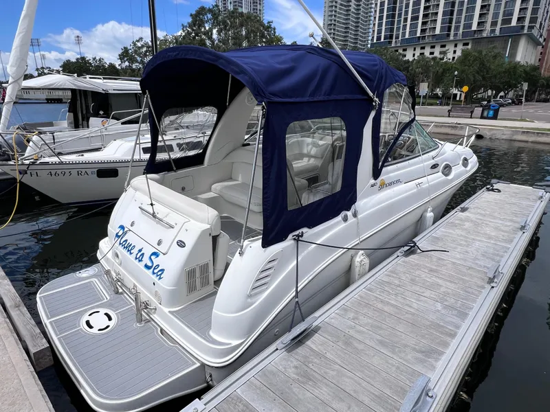 The Image of 2004 Sea Ray 260 Sundancer docked, featuring blue canopy and sleek white design. - 0