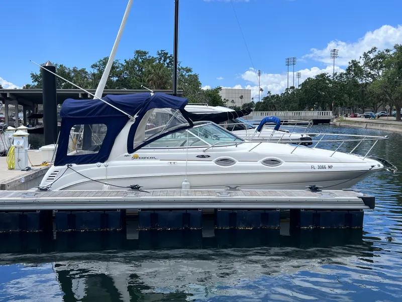 Slide: The Image of 2004 Sea Ray 260 Sundancer boat docked at marina under clear blue sky. - 1