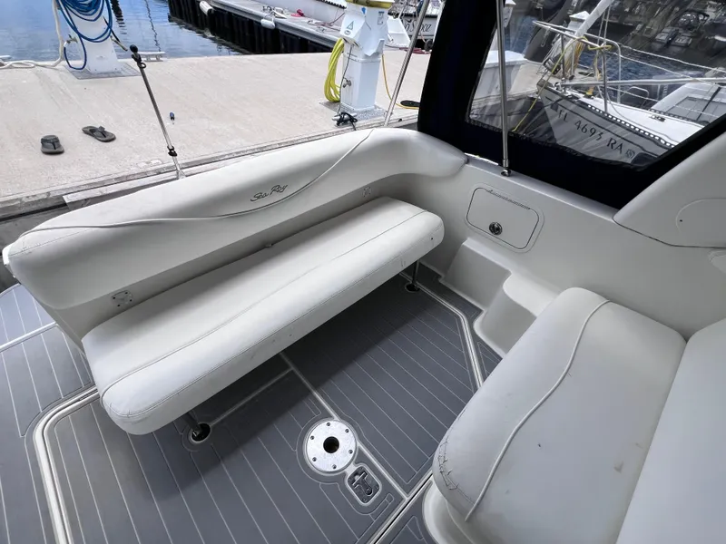 Slide: The Image of 2004 Sea Ray 260 Sundancer boat interior with white seating and gray flooring. - 10