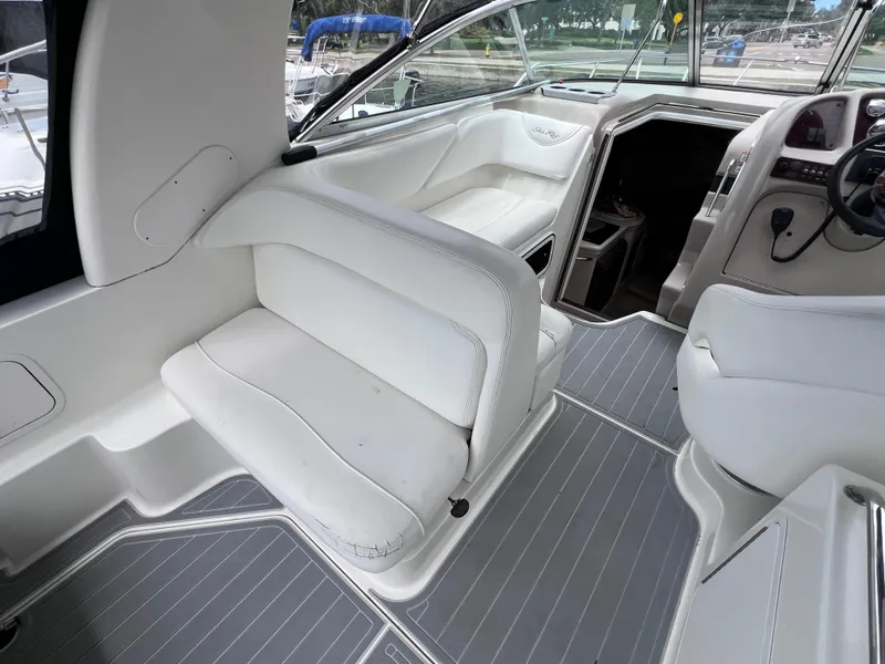 Slide: The Image of 2004 Sea Ray 260 Sundancer boat interior with white seating and modern dashboard. - 11