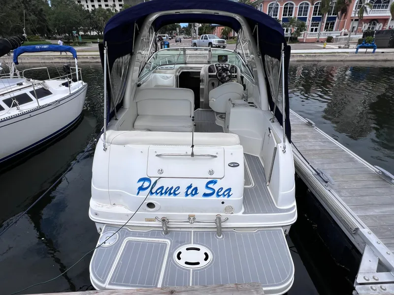 Slide: The Image of 2004 Sea Ray 260 Sundancer boat docked, featuring "Plane to Sea" on the stern. - 2