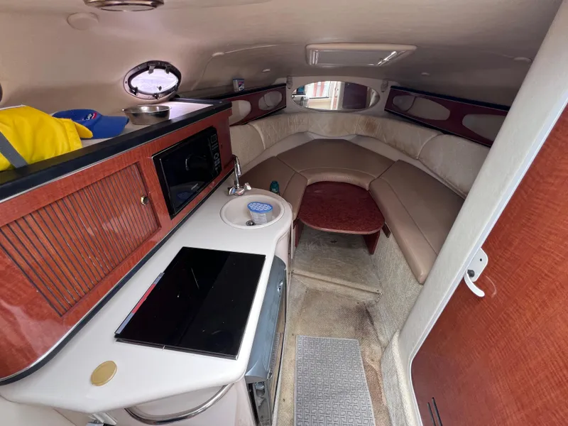 Slide: The Image of Interior of 2004 Sea Ray 260 Sundancer boat with kitchenette and seating area. - 21