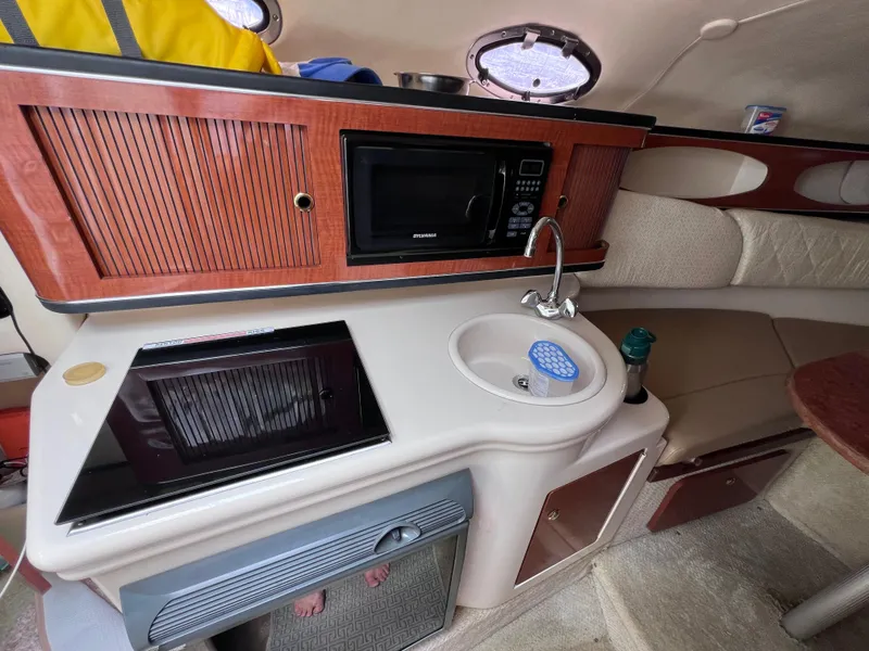 Slide: The Image of Interior of 2004 Sea Ray 260 Sundancer with kitchenette, sink, and microwave. - 24