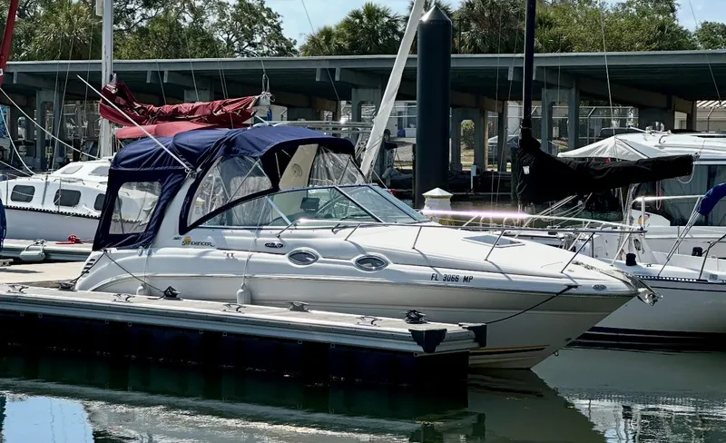 Slide: The Image of 2004 Sea Ray 260 Sundancer boat docked at marina with blue canopy. - 5