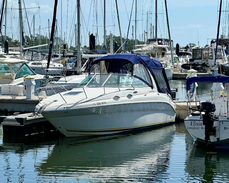 Slide: The Image of 2004 Sea Ray 260 Sundancer docked at a marina with other boats. - 6