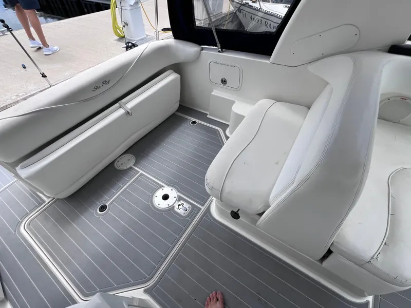 Slide: The Image of 2004 Sea Ray 260 Sundancer boat interior with white seating and gray flooring. - 9