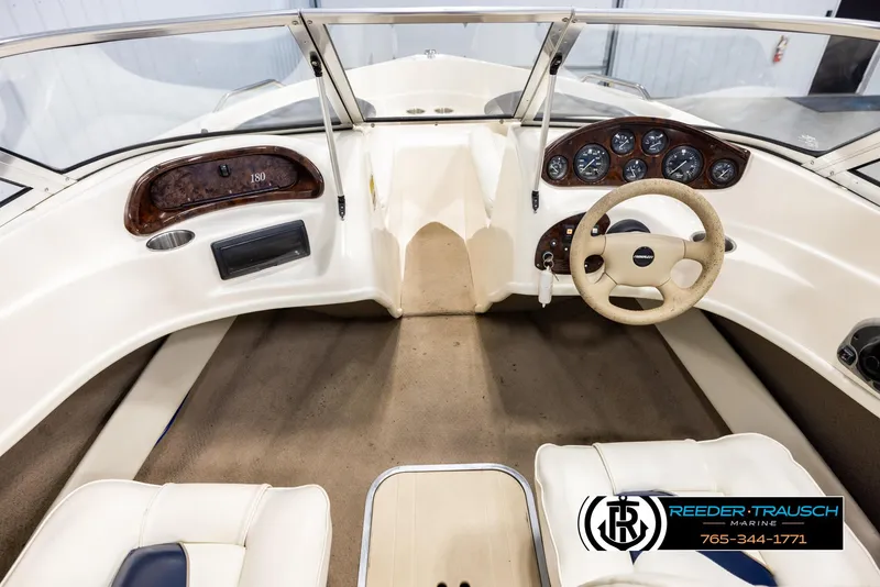 Slide: The Image of Interior of a 2002 Rinker 180 boat, featuring steering wheel and dashboard controls. - 13