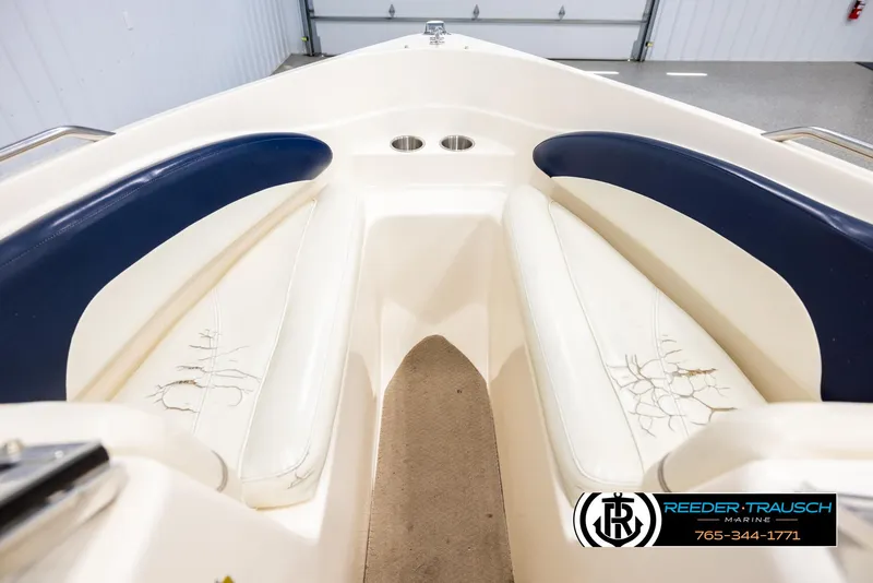 Slide: The Image of 2002 Rinker 180 boat interior with blue and white seating, visible wear on cushions. - 14